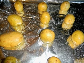 mini potatoes on a baking sheet lined with aluminum foil