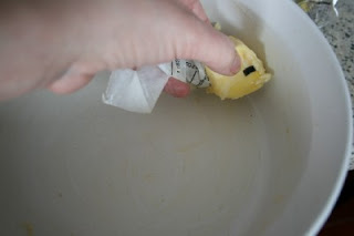 butter being rubbed on the inside of a casserole dish