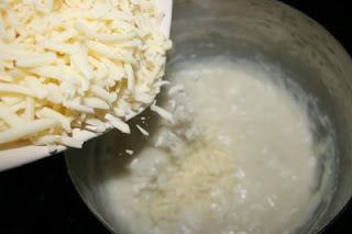 pouring shredded cheese into cooking pot