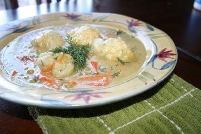 Bowl of Peas and Carrots Soup with Dumplings on a green towl