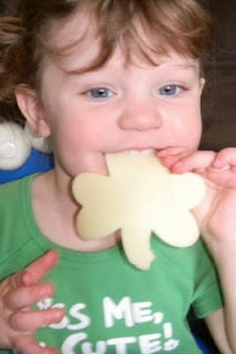 small child eating a cheese shamrock 