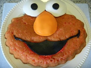 elmo cake with fondant eyes, nose and mouth placed on elmo cake