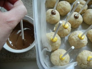 showing cake pop sticks dipped in candy melts, and then pushed into cake balls
