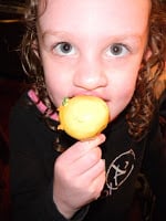 child eating a yellow cake pop