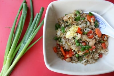  Top down photo fo the Fragrant Fried Rice Pilaf Recipe served in a off white bowl, with green onions on the side