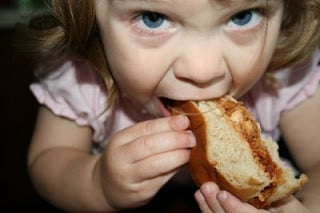 child biting into sandwich