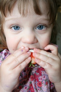 child eating a Red, White & Blue Chocolate Covered Strawberry