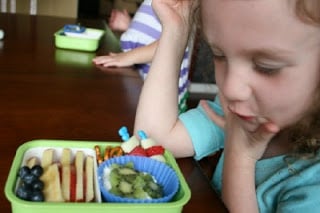 child sitting a a table looking at the Bento Love: Stars & Stripes 4th of July Lunchbox