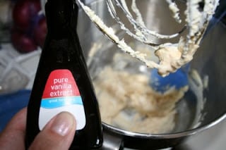 holding bottle of vanilla extract over stand mixer
