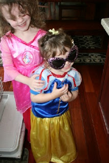 two children dressed up as princesses, standing together