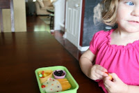 child sitting at the table with the cupcake surprise lunchbox