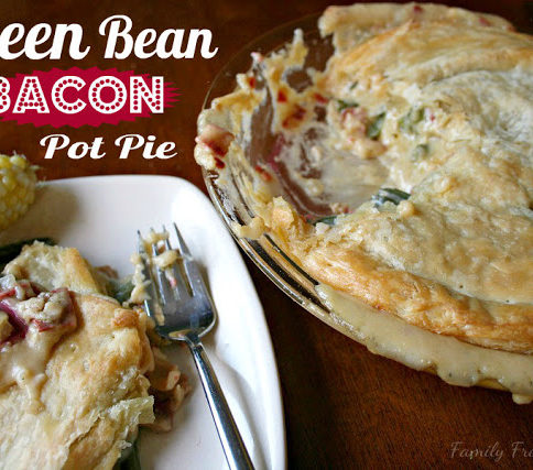 Cheesy Green Bean & Bacon Pot Pie , served on a white plate with a side of corn on the cob