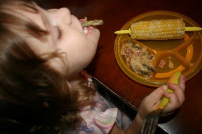 child sitting at a table eating Cheesy Green Bean & Bacon Pot Pie 