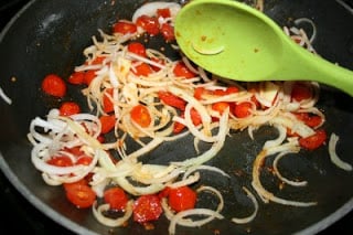 sliced leeks and tomatoes in a cooking pan