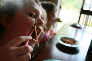 2 children sitting at a table eating BLT Pasta