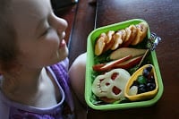 child sitting at a table with Bento Love: Trick or Treat Halloween Lunchbox 