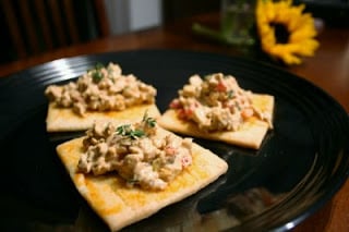 three  pieces of Thai Chicken Salad Appetizer on a black plate with sunflower in the background