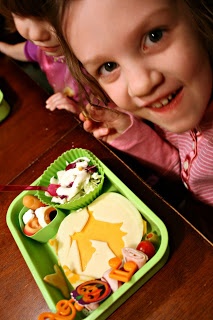 2 children sitting a table smiling with Witch Wonder Lunchbox