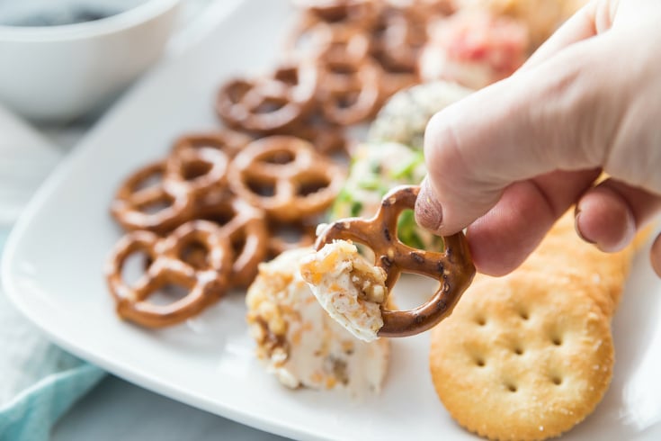 Mini Cheese Balls - scooping mini cheese ball with a pretzels