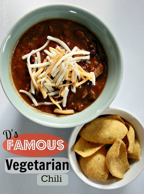 top down photo of Darryl's Famous Vegetarian Chili, topped with shredded cheese and a side of corn chips