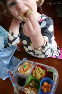 Child sitting at a table eating Hot Dog Kabob lunch box