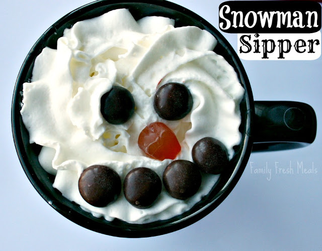 Top down image of Snowman Hot Chocolate Sipper - hot cocoa topped with whipped cream, m and m's and gummy