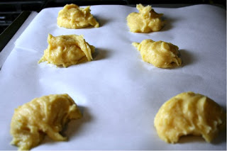 Cream puff shell batter on baking sheet lined with parchment paper