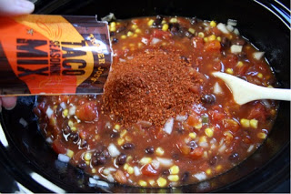 Crockpot Chicken Taco Soup - Sprinkling taco seasoning into crockpot