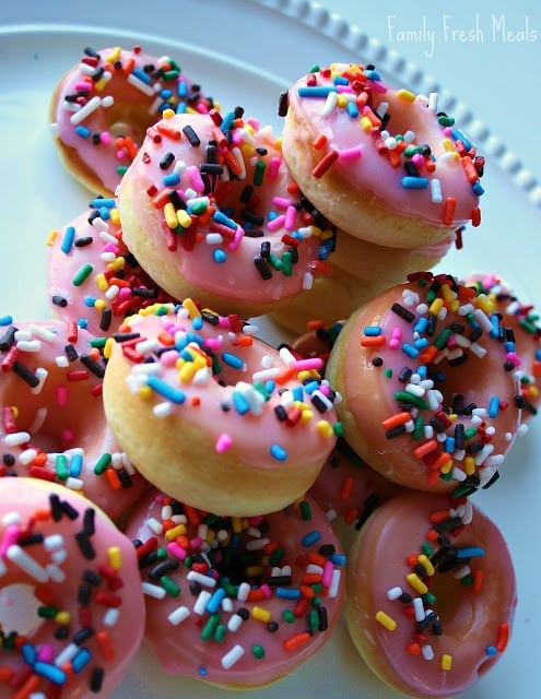 Stack of pink sprinkles mini donuts on a white platter