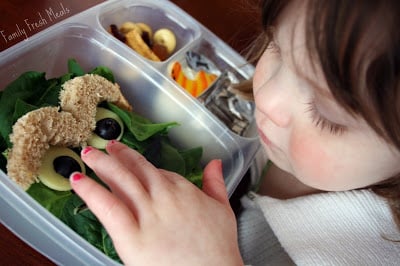 small child looking at Oscar the Grouch lunchbox