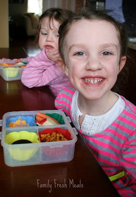 2 children sitting at a table with Spring Snack Lunch Box