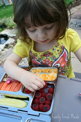 child sitting at a picnic table eating the Antipasto Lunchbox