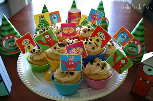 Chocolate Chip Cookie Dough Cupcakes on a serving plater, decorated with Yo Gabba Gabba food picks