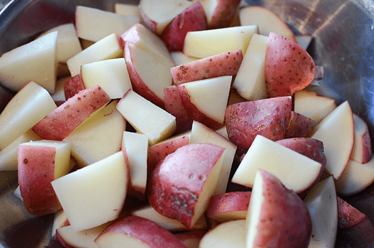 red potatoes cut up in a mixing bowl