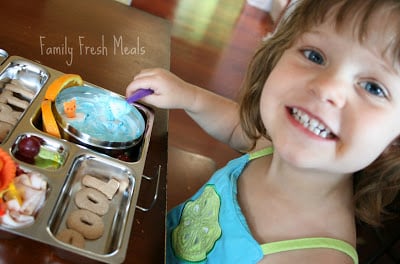 Child sitting at a table with pool party themed lunchbox