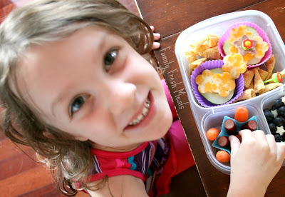 child sitting at table with lunchbox