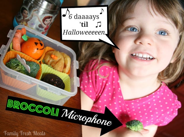 child sitting at table with halloween themed lunchbox. Speech bubble coming from her mouth saying 6 Daaaaaaays 'til Halloweeeeen