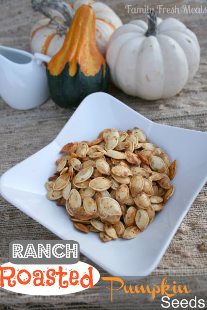 Ranch Roasted Pumpkin Seeds served in a white bowl with small gourds in the background 