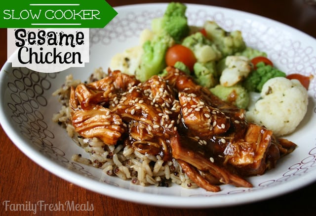 Slow Cooker Sesame Chicken served on a white plate over brown rice, with a side of vegetables