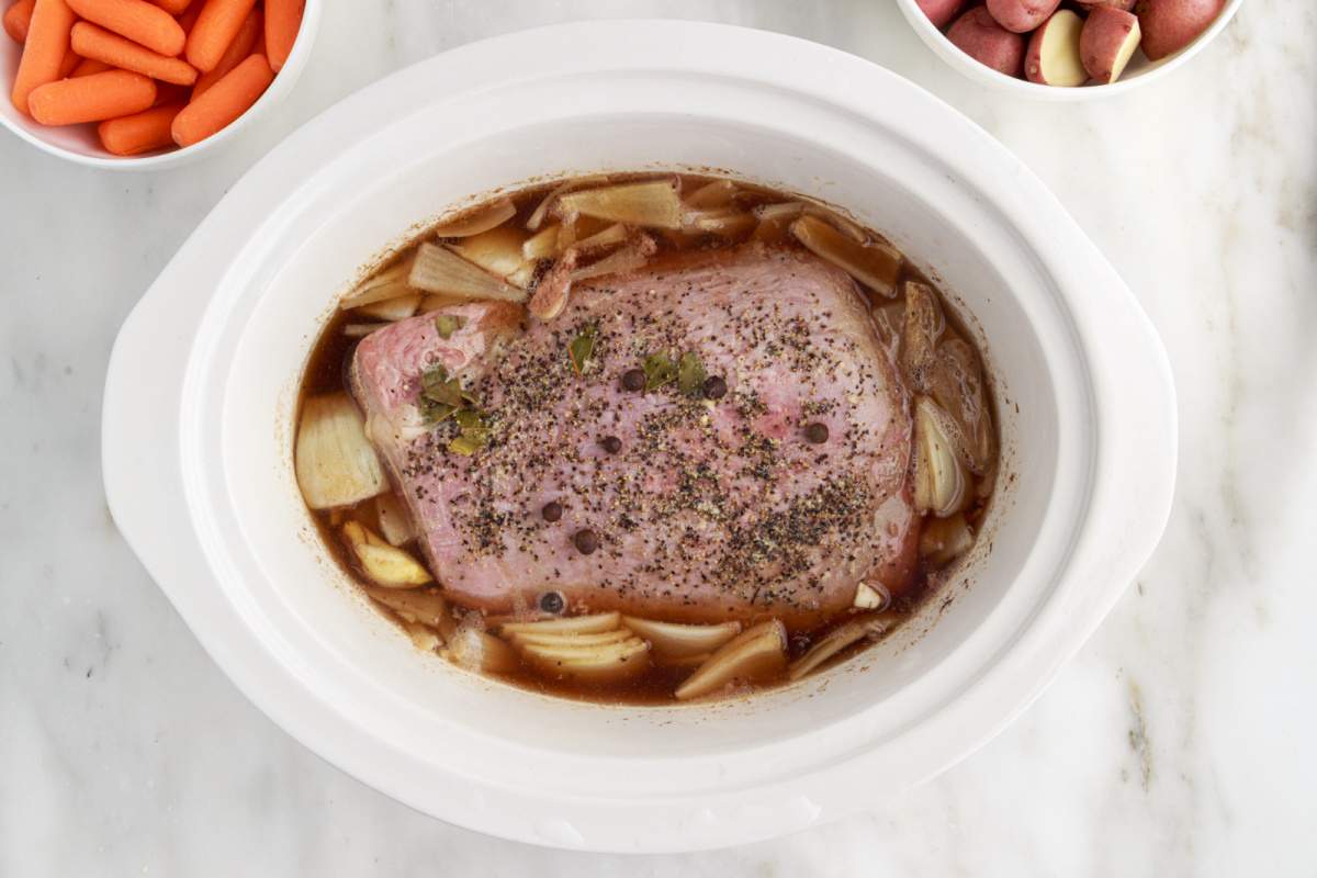 corned beef onion and seasoning in a slow cooker