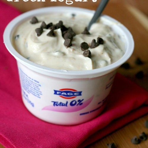 cookie dough greek yogurt in Fage yogurt container topped with mini chocolate chips and a spoon