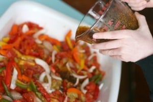 pouring seasoning over chicken and vegetables 