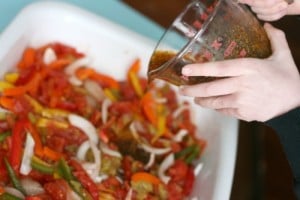 pouring seasoning over chicken and vegetables 