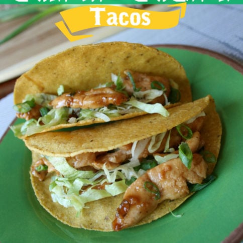 two Chinese chicken tacos on a green plate