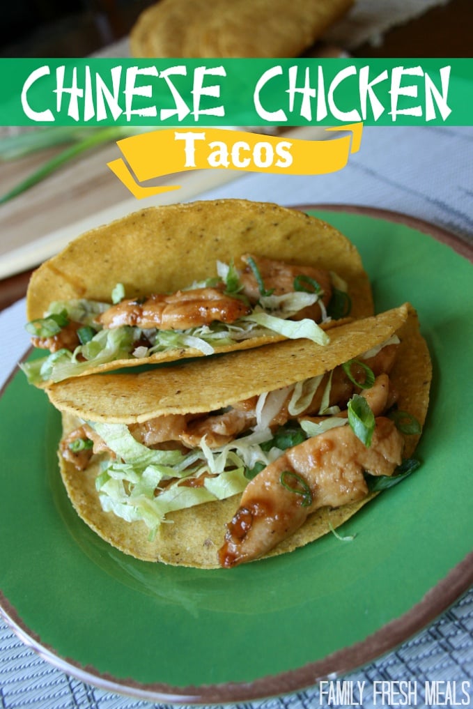 two Chinese chicken tacos on a green plate