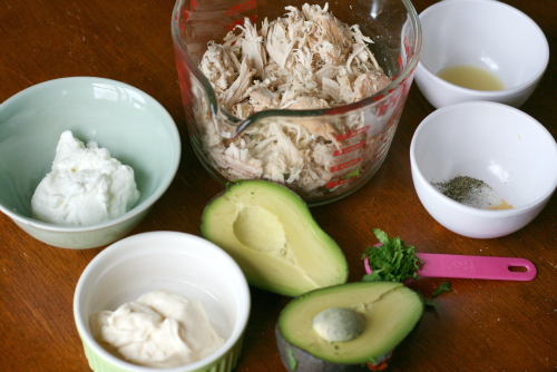 Shredded chicken, avocado, Greek yogurt, mayo, lime and cilantro in a glass mixing bowl