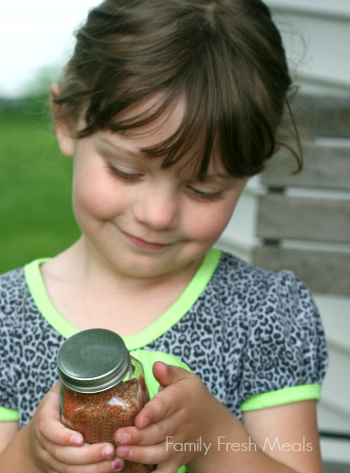 Child holding a jar of the Best Burger and French Fry Seasoning