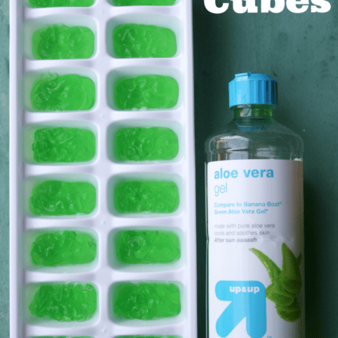 ice cube tray filled with aloe vera gel, with a bottle of aloe vera next to it