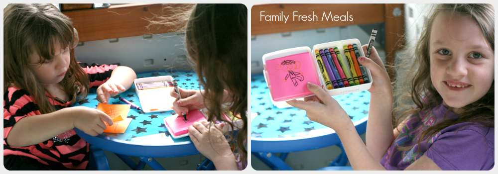 children sitting at a small table using the DIY Traveling Coloring Case to color
