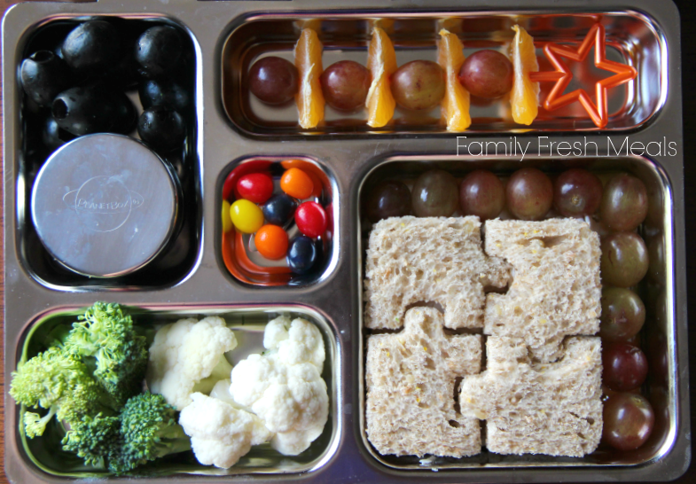 top down picture of a metal lunchbox packed with a variety of finger foods